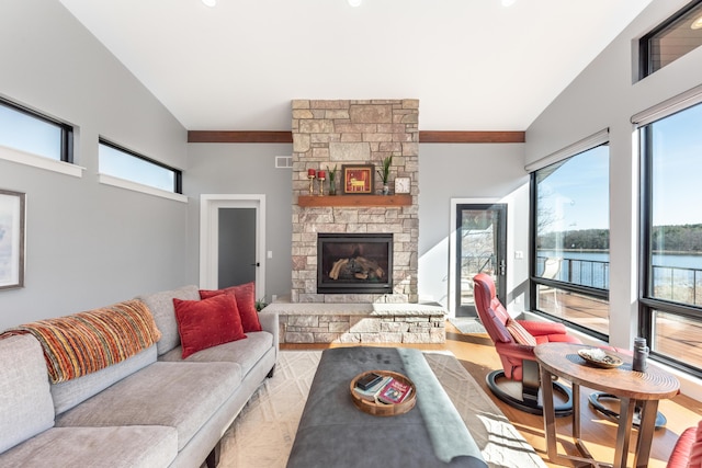 10485 Hadley Rd, Gregory, MI 48137 - living room with visible vents, a fireplace, vaulted ceiling, and a water view