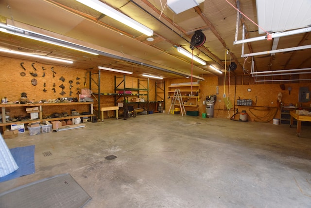 garage featuring a garage door opener, a workshop area, and electric panel