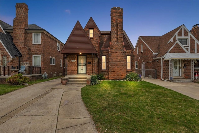 18645 Cherrylawn St, Detroit, MI 48221 - tudor house featuring a front yard, brick siding, and a chimney
