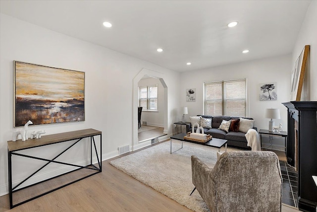 18645 Cherrylawn St, Detroit, MI 48221 - living room with arched walkways, wood finished floors, visible vents, and a healthy amount of sunlight