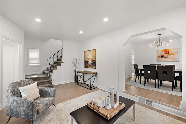 18645 Cherrylawn St, Detroit, MI 48221 - living area with arched walkways, an inviting chandelier, recessed lighting, wood finished floors, and stairs