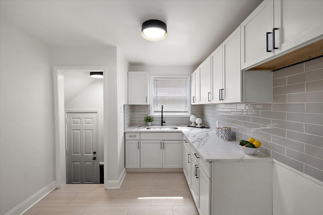 18645 Cherrylawn St, Detroit, MI 48221 - kitchen with baseboards, a sink, white cabinetry, backsplash, and light stone counters