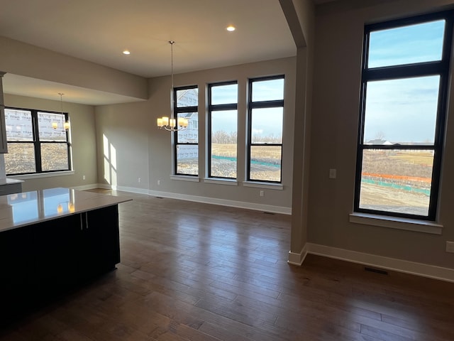 60671 Town Square St, New Hudson, MI 48165 - unfurnished dining area with dark wood-type flooring, arched walkways, recessed lighting, a chandelier, and baseboards