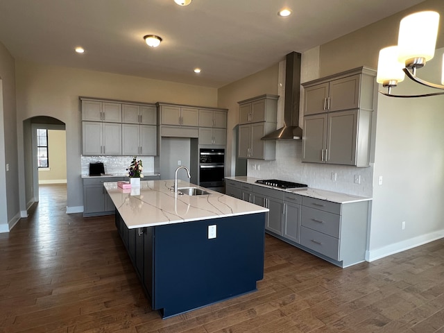 60671 Town Square St, New Hudson, MI 48165 - kitchen with arched walkways, a sink, wall chimney range hood, gray cabinets, and gas cooktop