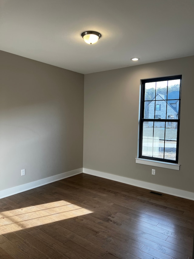 60671 Town Square St, New Hudson, MI 48165 - empty room with dark wood-type flooring, visible vents, baseboards, and recessed lighting
