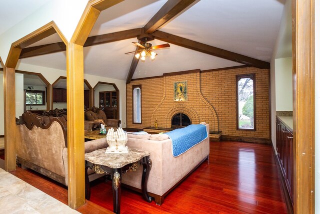 46498 Houghton Dr, Shelby, MI 48315 - living room featuring a fireplace, lofted ceiling with beams, a ceiling fan, brick wall, and dark wood-style floors