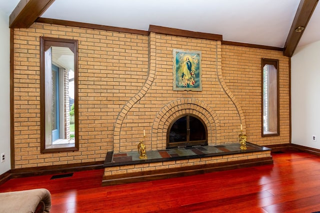 46498 Houghton Dr, Shelby, MI 48315 - unfurnished living room featuring visible vents, wood finished floors, brick wall, baseboards, and beam ceiling