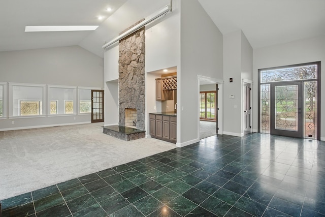 4489 Cranbrook Trl, Orchard Lake, MI 48323 - unfurnished living room featuring high vaulted ceiling, a fireplace, carpet flooring, and baseboards