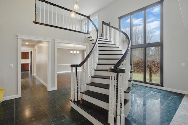4489 Cranbrook Trl, Orchard Lake, MI 48323 - stairway with baseboards, a chandelier, and a towering ceiling