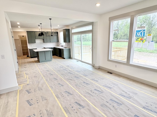 8284 Kettle Oak Dr, Alto, MI 49302 - kitchen with healthy amount of natural light, a kitchen island, a sink, decorative backsplash, and recessed lighting