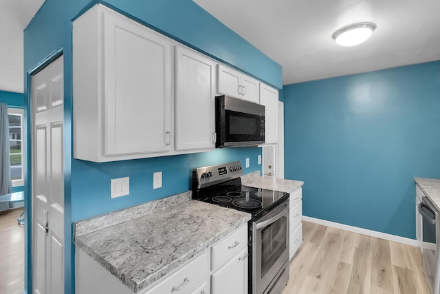 kitchen with light wood finished floors, white cabinetry, baseboards, and stainless steel range with electric cooktop