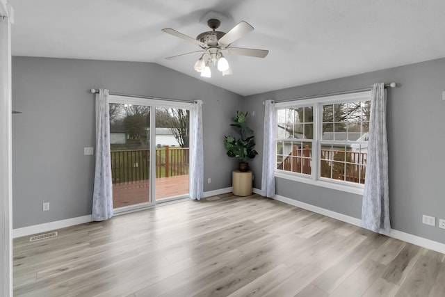 unfurnished room featuring ceiling fan, visible vents, wood finished floors, lofted ceiling, and baseboards