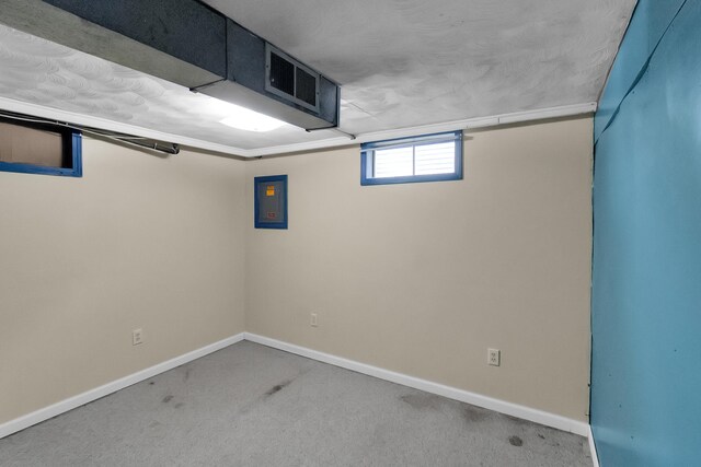 below grade area featuring electric panel, carpet, and baseboards