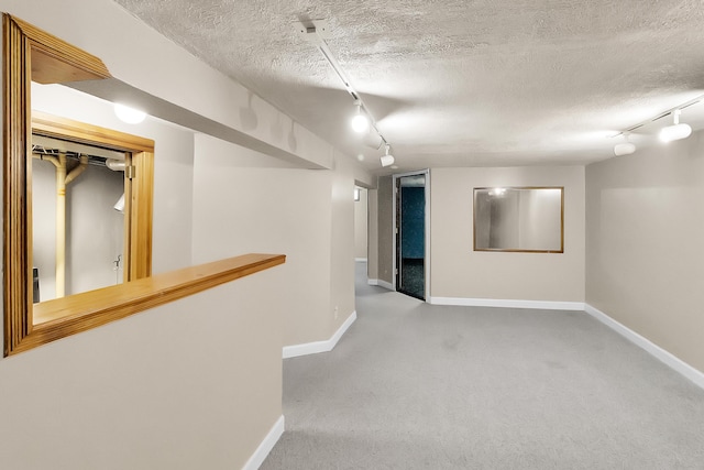 interior space with a textured ceiling, baseboards, and carpet