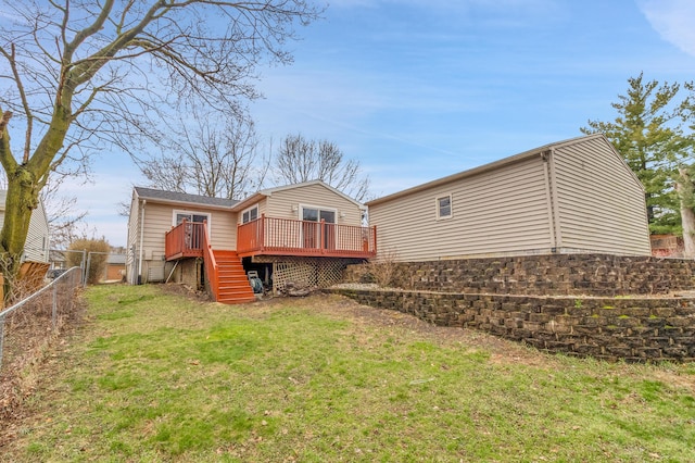 rear view of house featuring a deck, fence, stairway, and a lawn