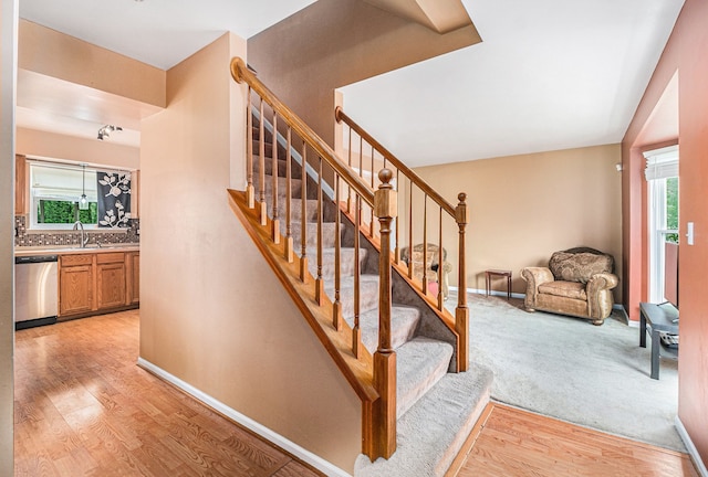 stairs with wood finished floors and baseboards