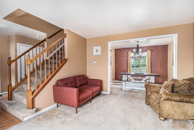 living room featuring stairway, a chandelier, baseboards, and light colored carpet