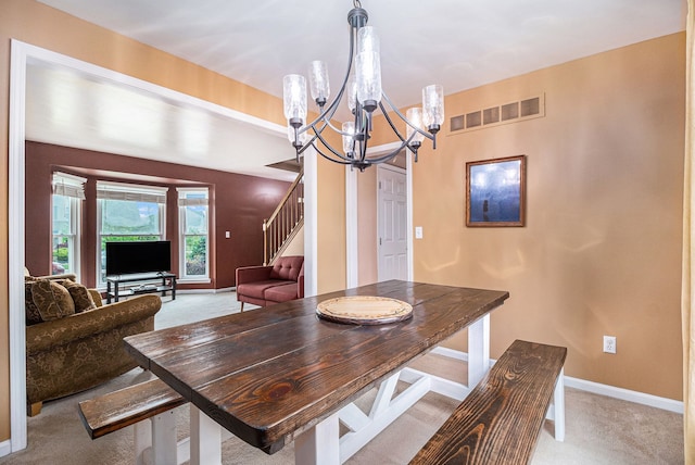dining area featuring light colored carpet, a chandelier, baseboards, and stairs