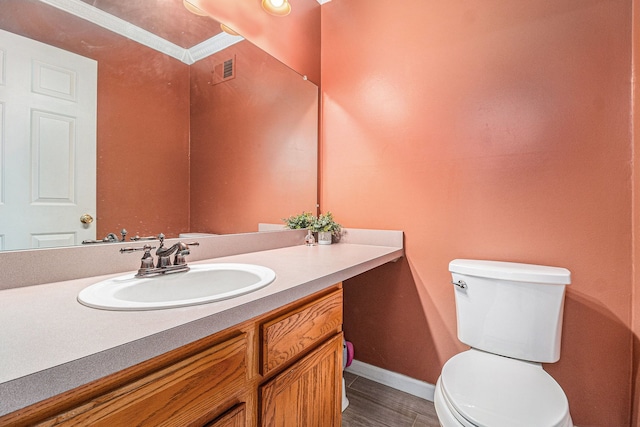 bathroom featuring vanity, toilet, and baseboards