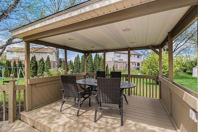 deck featuring outdoor dining space and a yard