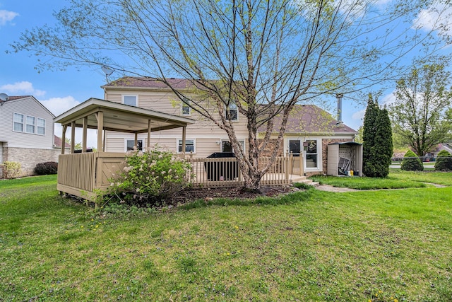 rear view of property featuring a deck and a yard