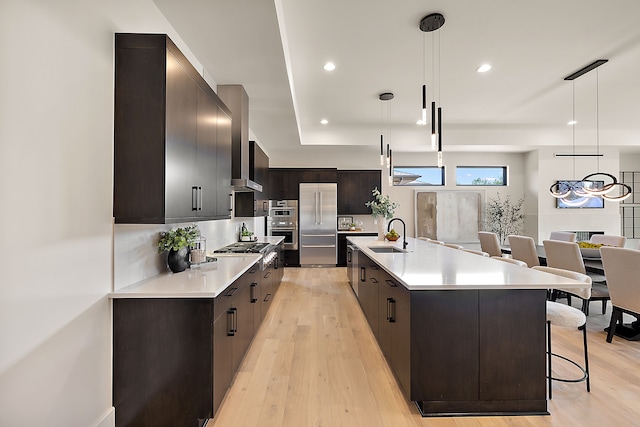 49351 Villa Dr, Novi, MI 48374 - kitchen with appliances with stainless steel finishes, modern cabinets, a kitchen breakfast bar, a sink, and dark brown cabinetry