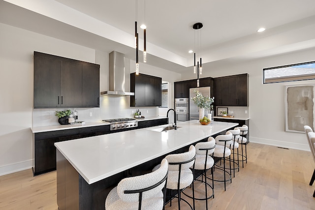 49351 Villa Dr, Novi, MI 48374 - kitchen with wall chimney exhaust hood, a sink, baseboards, a kitchen breakfast bar, and light wood-style floors