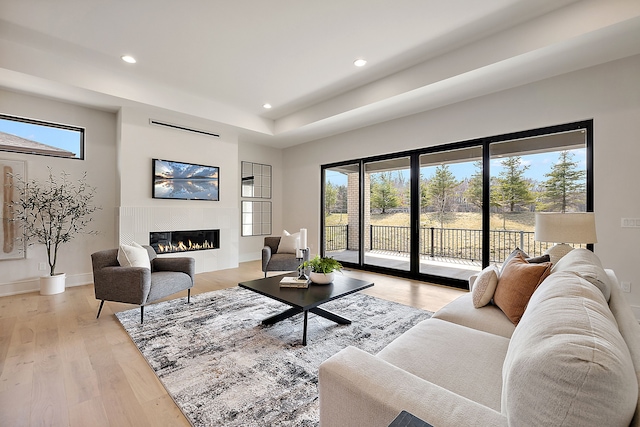 49351 Villa Dr, Novi, MI 48374 - living room with a glass covered fireplace, recessed lighting, light wood-type flooring, a raised ceiling, and baseboards