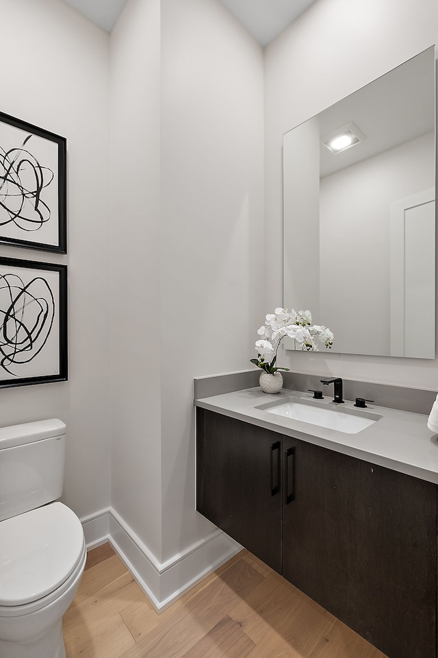 49351 Villa Dr, Novi, MI 48374 - half bathroom featuring wood finished floors, toilet, vanity, and baseboards