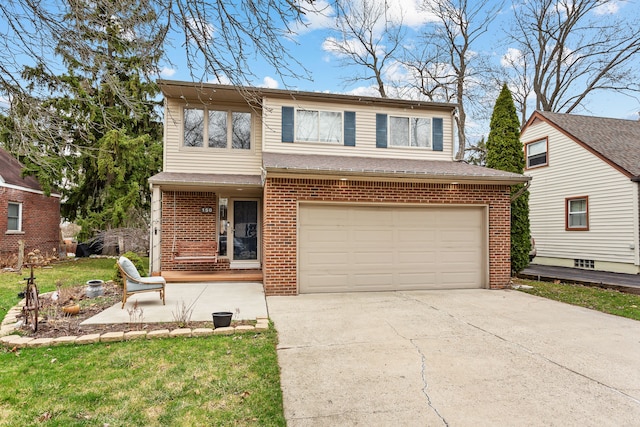 traditional-style house with an attached garage, concrete driveway, a front yard, and brick siding