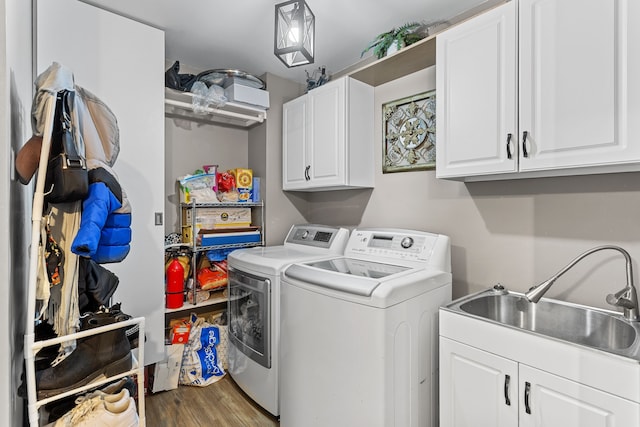 washroom featuring cabinet space, independent washer and dryer, wood finished floors, and a sink