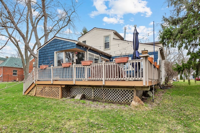 back of property featuring a wooden deck and a lawn