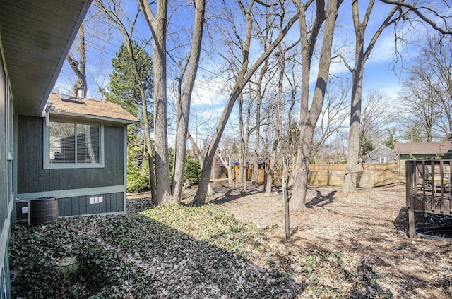view of yard featuring central AC unit and fence