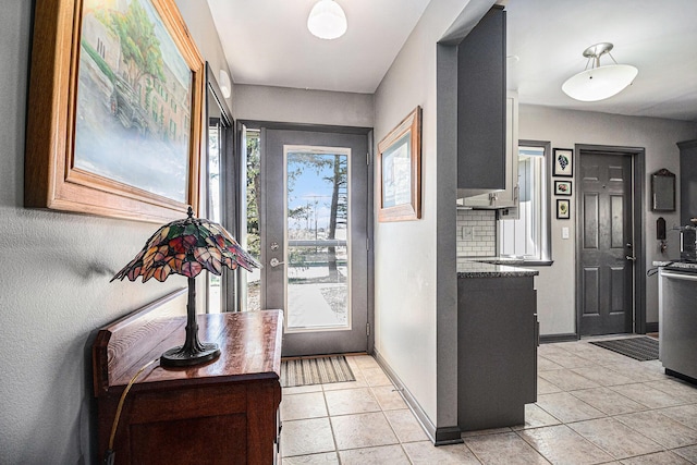 doorway to outside featuring light tile patterned floors and baseboards