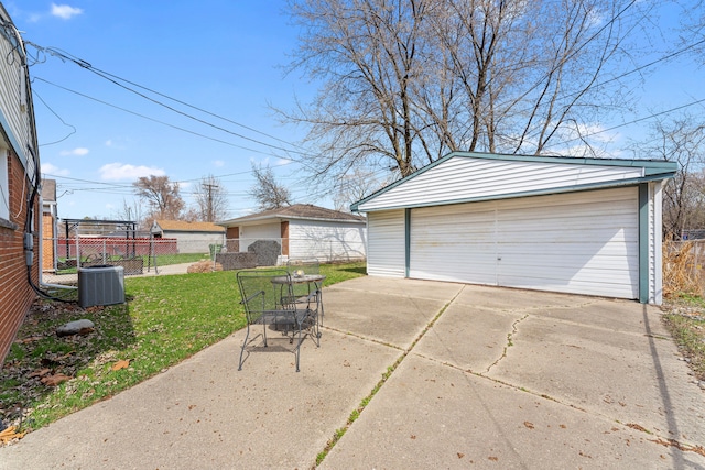 detached garage with central AC unit and fence