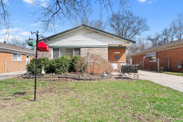 back of property with a yard, a patio area, and brick siding