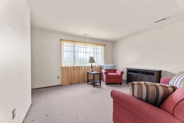 living area with a fireplace, carpet flooring, and visible vents