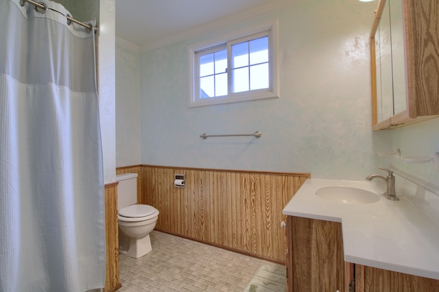 bathroom with vanity, ornamental molding, toilet, wainscoting, and wooden walls