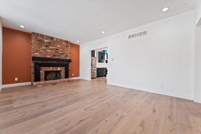 1459 Edison St, Detroit, MI 48206 - unfurnished living room with visible vents, recessed lighting, light wood-type flooring, and a brick fireplace