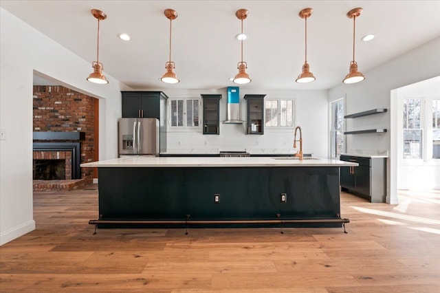 1459 Edison St, Detroit, MI 48206 - kitchen with wall chimney range hood, stainless steel refrigerator with ice dispenser, light countertops, and a sink