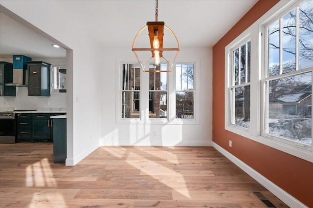 1459 Edison St, Detroit, MI 48206 - unfurnished dining area with light wood-style floors, baseboards, visible vents, and a notable chandelier