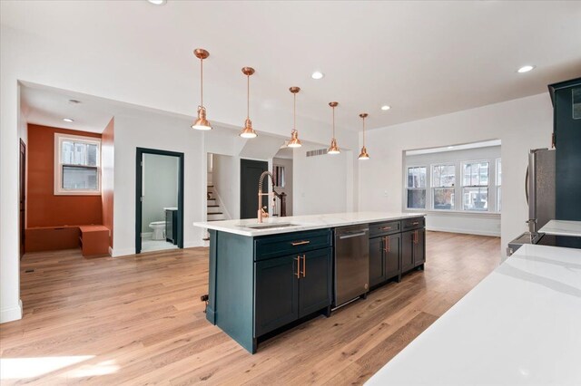 1459 Edison St, Detroit, MI 48206 - kitchen with decorative light fixtures, light wood-style floors, a center island with sink, stainless steel appliances, and a sink