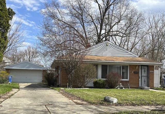 3851 Wellington St, Inkster, MI 48141 - view of front of house with an outbuilding, a detached garage, concrete driveway, brick siding, and a front yard