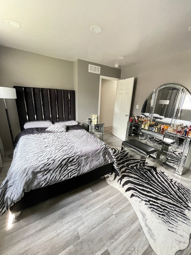 bedroom with visible vents and wood finished floors