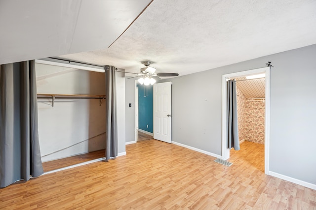 6308 E Becht Rd, Coloma, MI 49038 - unfurnished bedroom with baseboards, light wood-type flooring, ceiling fan, and a textured ceiling