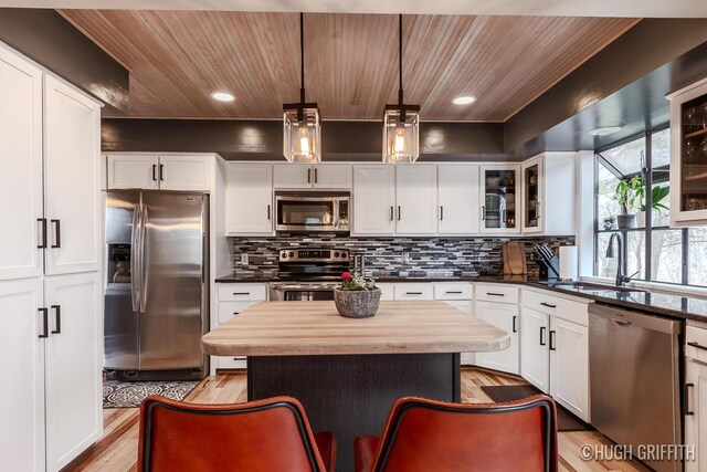 2376 Bob White Ct SE, Grand Rapids, MI 49546 - kitchen with light wood-type flooring, backsplash, glass insert cabinets, and stainless steel appliances