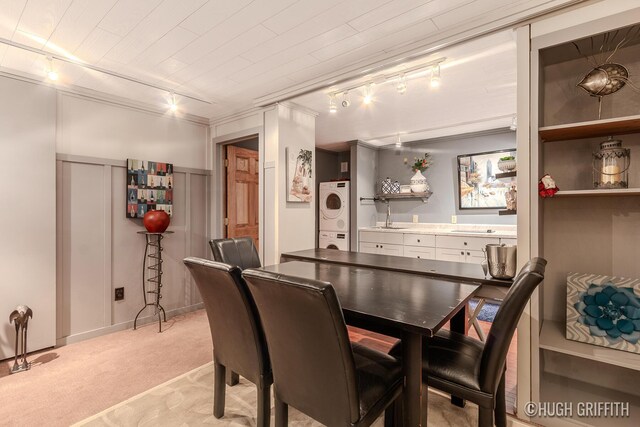 2376 Bob White Ct SE, Grand Rapids, MI 49546 - dining space featuring track lighting, light colored carpet, and stacked washer and clothes dryer