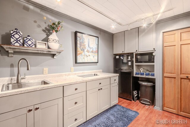 2376 Bob White Ct SE, Grand Rapids, MI 49546 - kitchen with light stone countertops, light wood finished floors, a sink, and black appliances