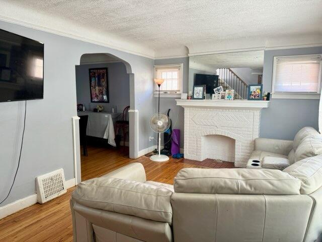 5793 Yorkshire Rd, Detroit, MI 48224 - living area with visible vents, baseboards, a textured ceiling, stairway, and wood finished floors