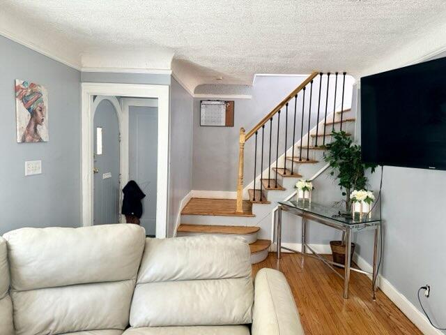 5793 Yorkshire Rd, Detroit, MI 48224 - stairway featuring a textured ceiling, baseboards, and wood finished floors
